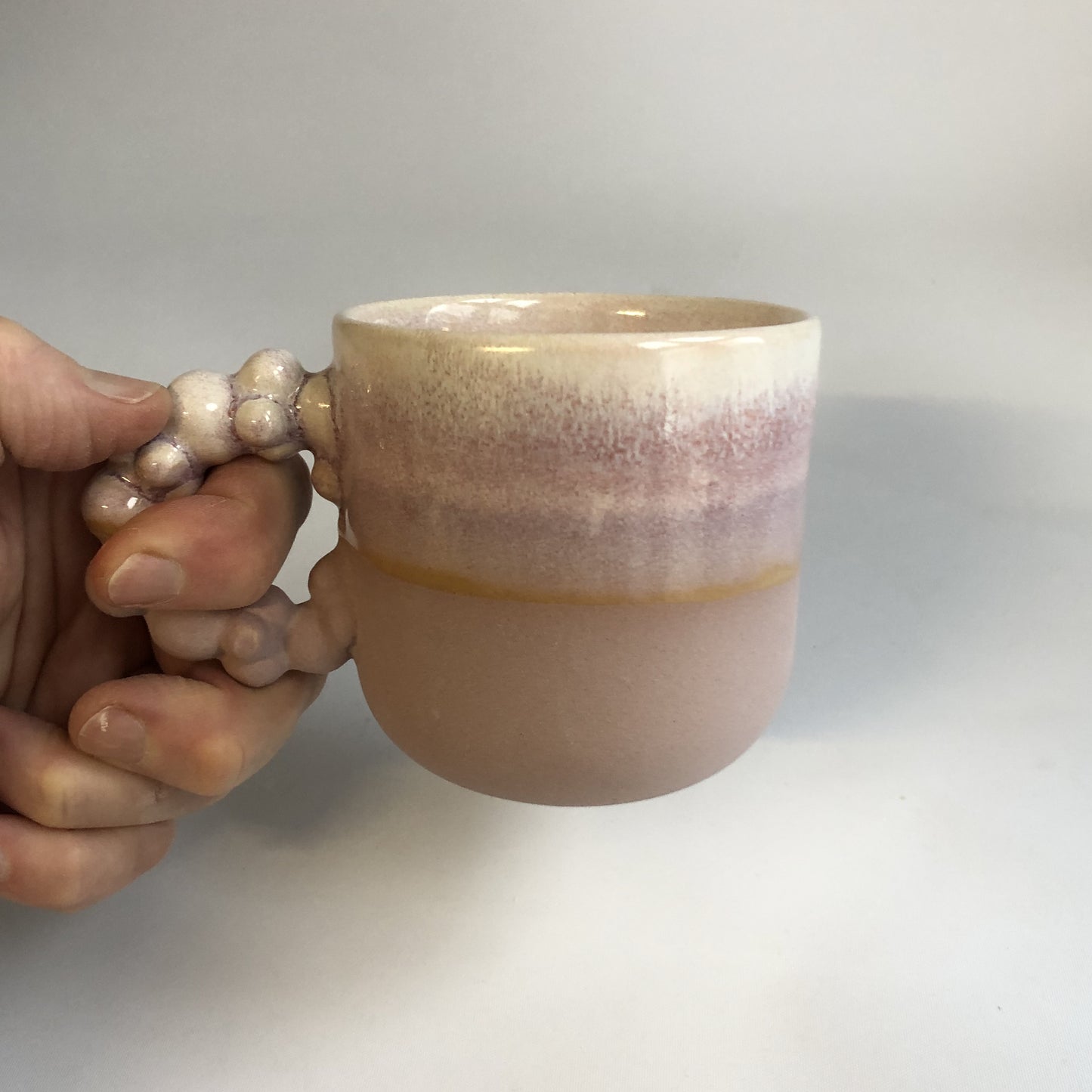 Lille kop med lilla mat bund og lyserød glasur