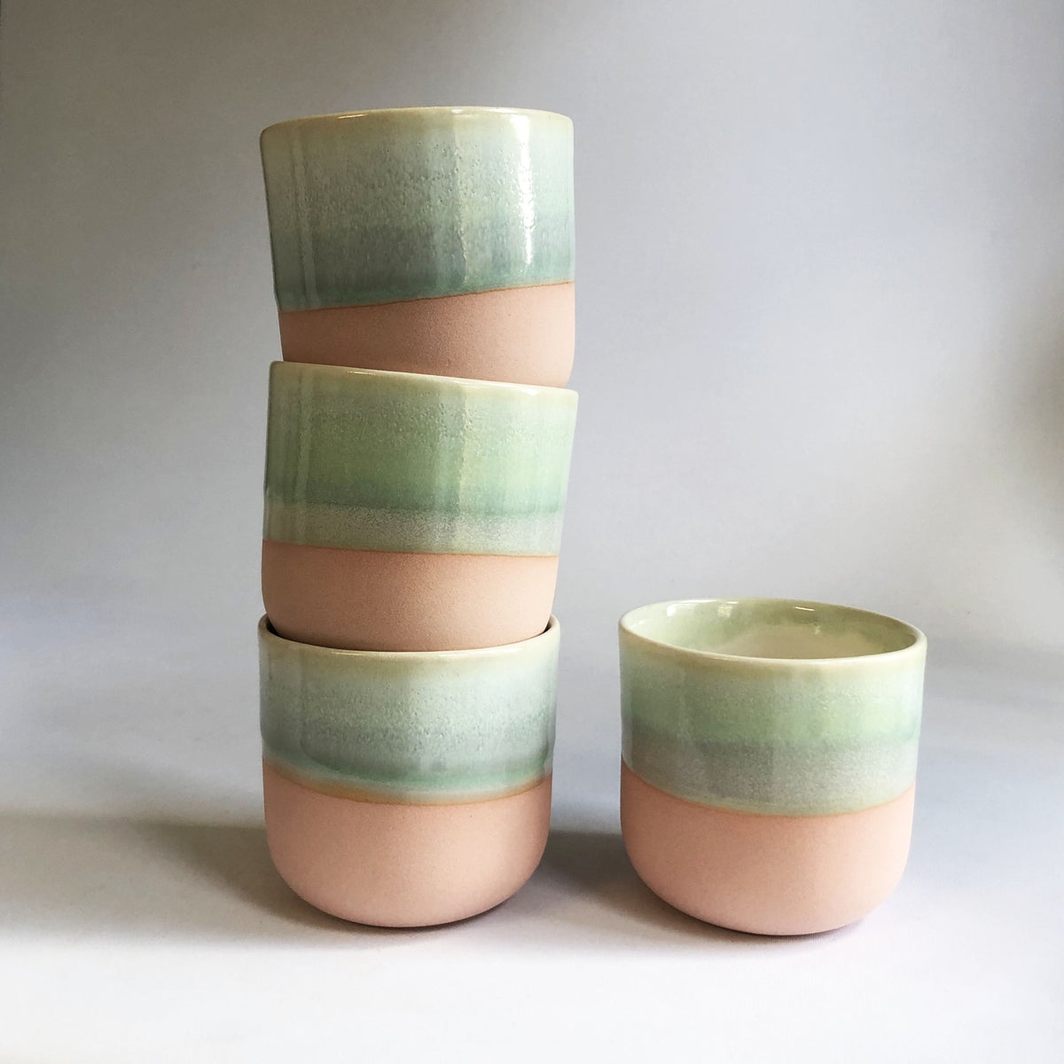 Little cup without handle with a matte light pink base and green glaze