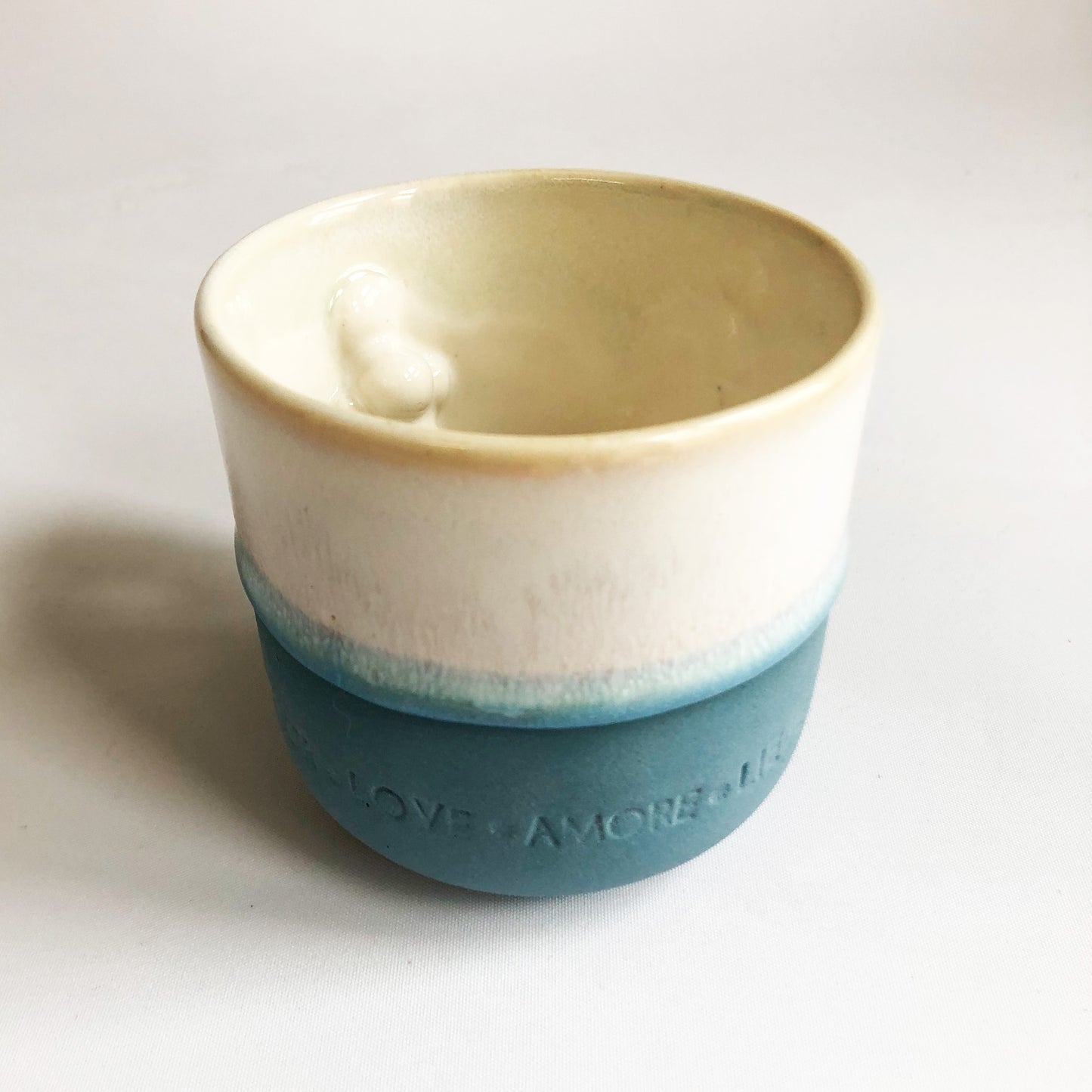 Big cup with text. The cup has a blue matte bottom and white glaze