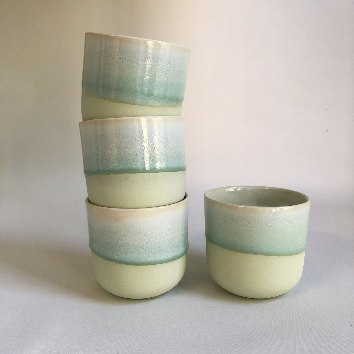 Large handleless cup with a matte green bottom and green glaze