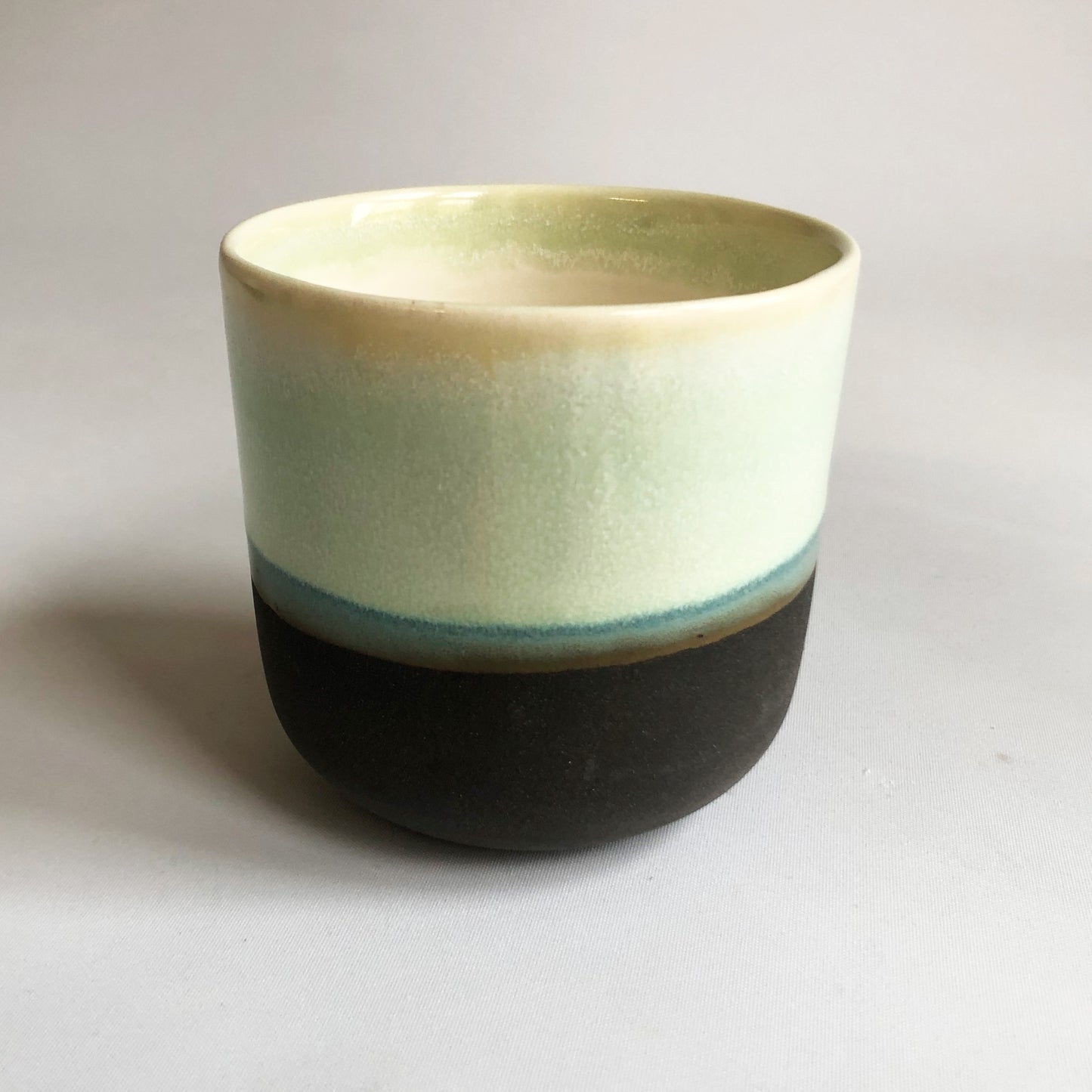 Big cup without handle with black matte bottom and green glaze