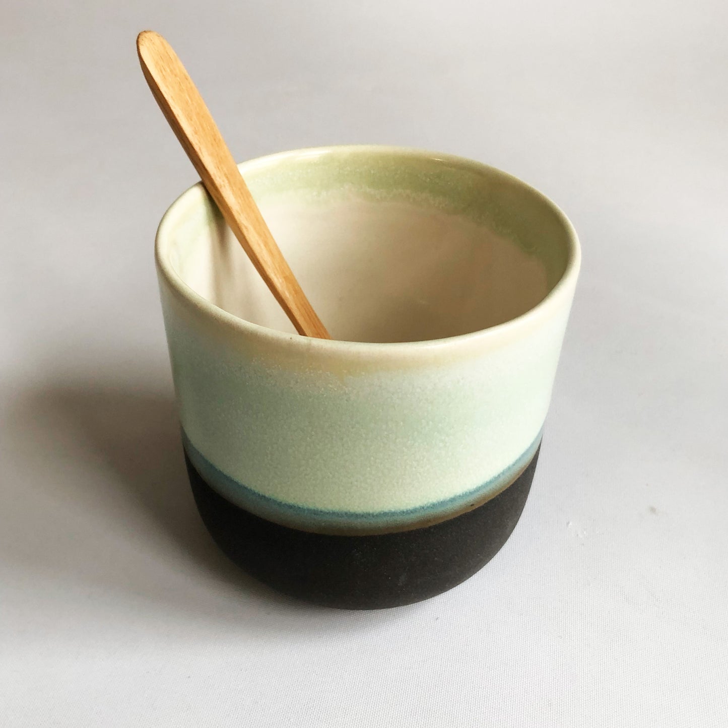 Big cup without handle with black matte bottom and green glaze