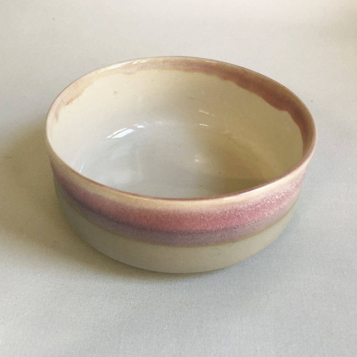 Large bowl with matte light grey base and light pink glaze