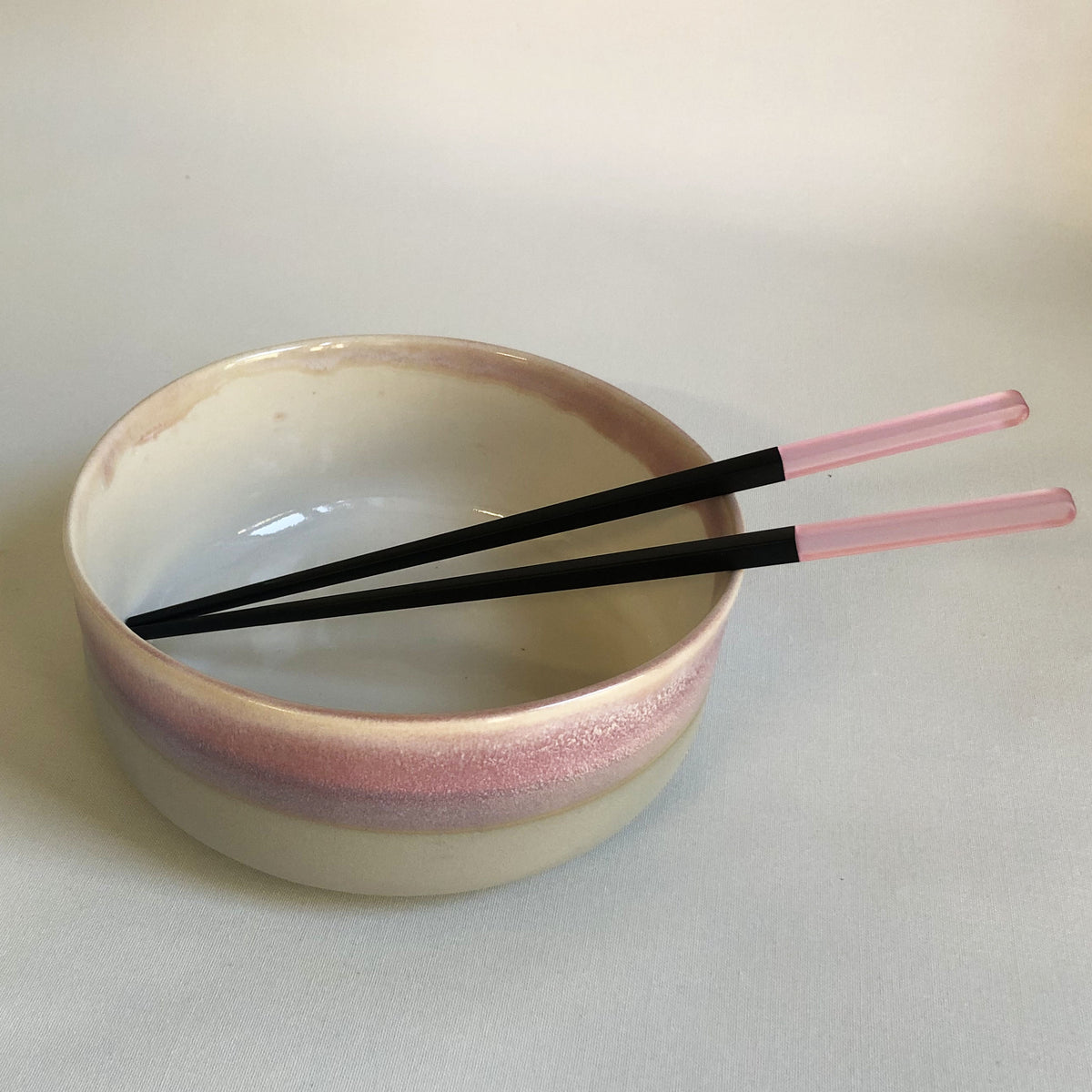 Large bowl with matte light grey base and light pink glaze