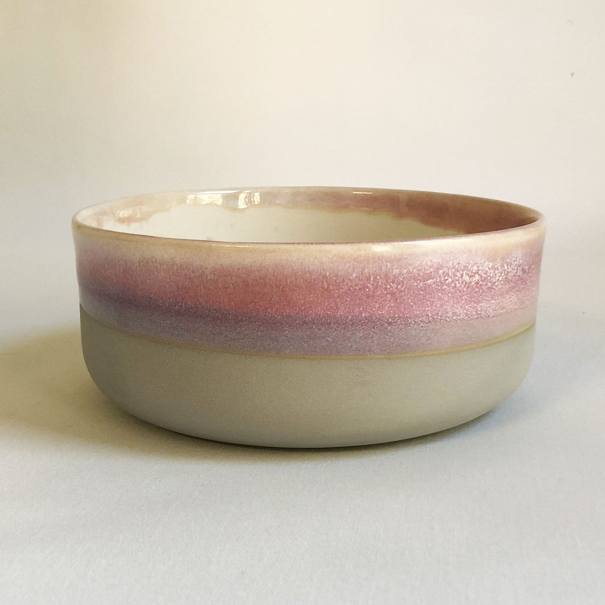 Large bowl with matte light grey base and light pink glaze