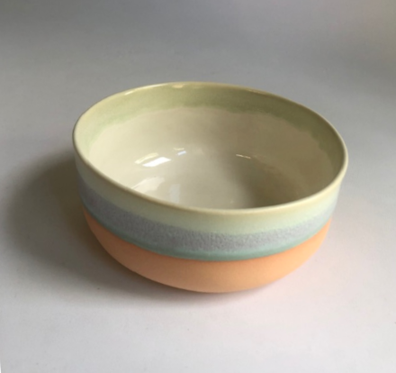 Small bowl with a matte coral-colored base and green glaze