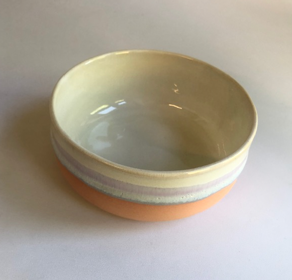 Small bowl with matte coral-colored base and ice-blue glaze