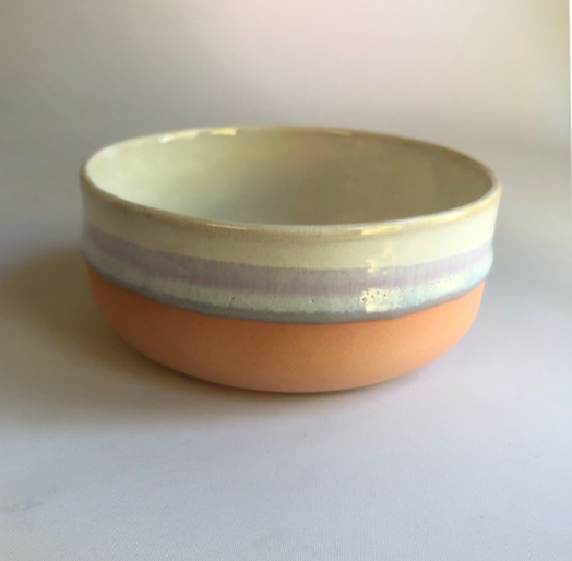 Small bowl with matte coral-colored base and ice-blue glaze