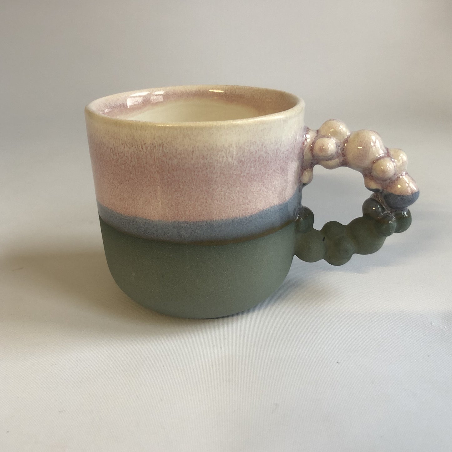 Lille kop med mat koksgrå bund og lyserød glasur