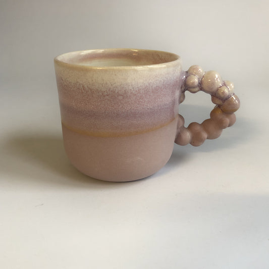 Lille kop med lilla mat bund og lyserød glasur