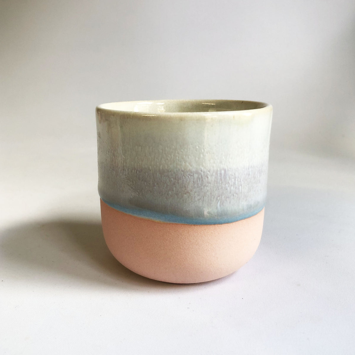 Little cup without a handle with a matte pink base and ice-blue glaze