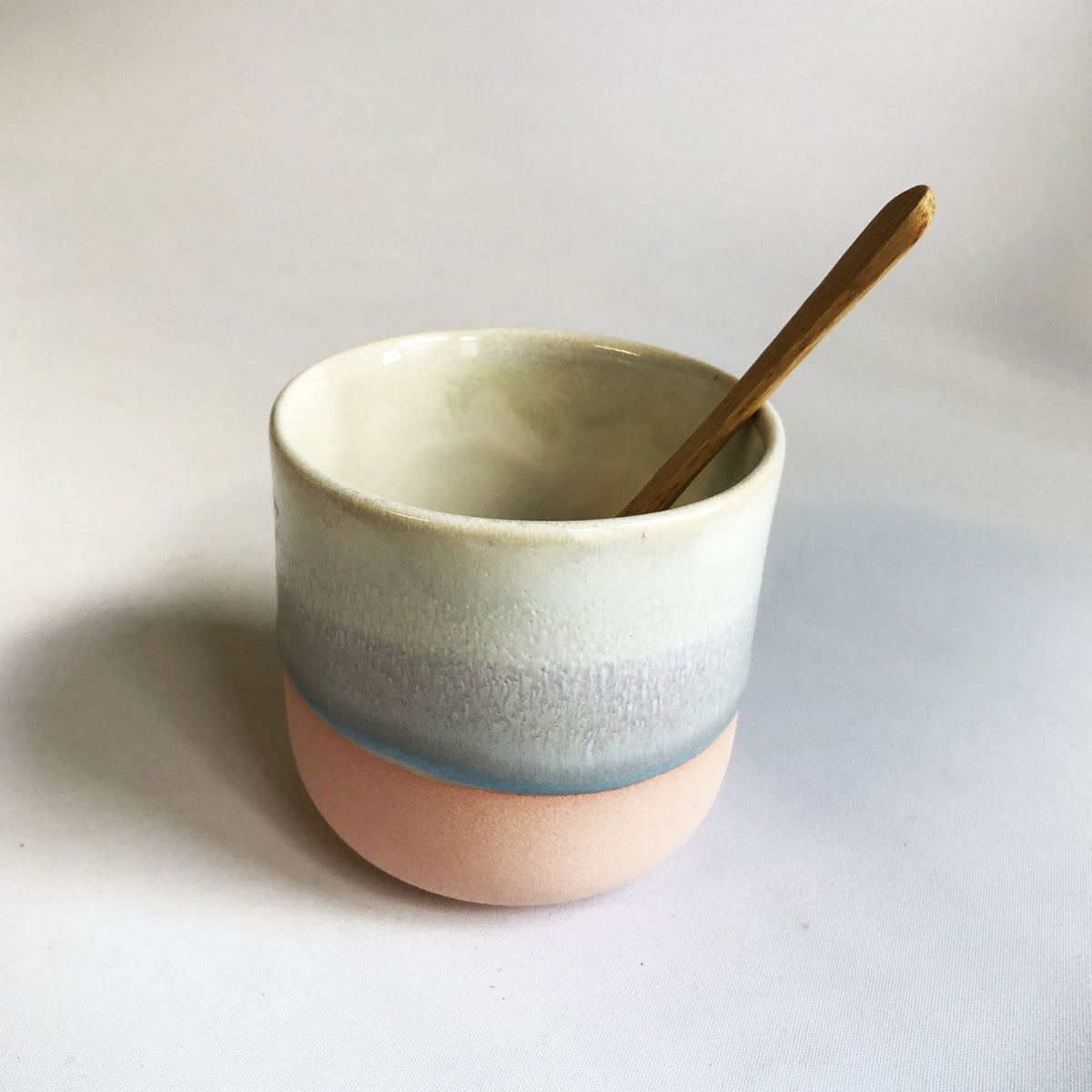 Little cup without a handle with a matte pink base and ice-blue glaze