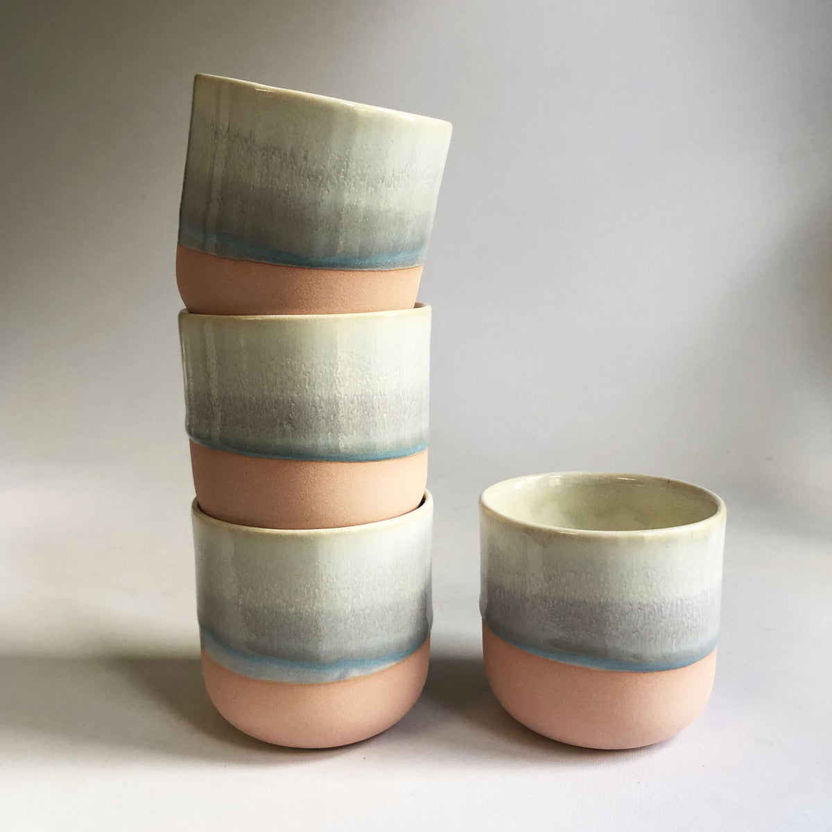 Little cup without a handle with a matte pink base and ice-blue glaze