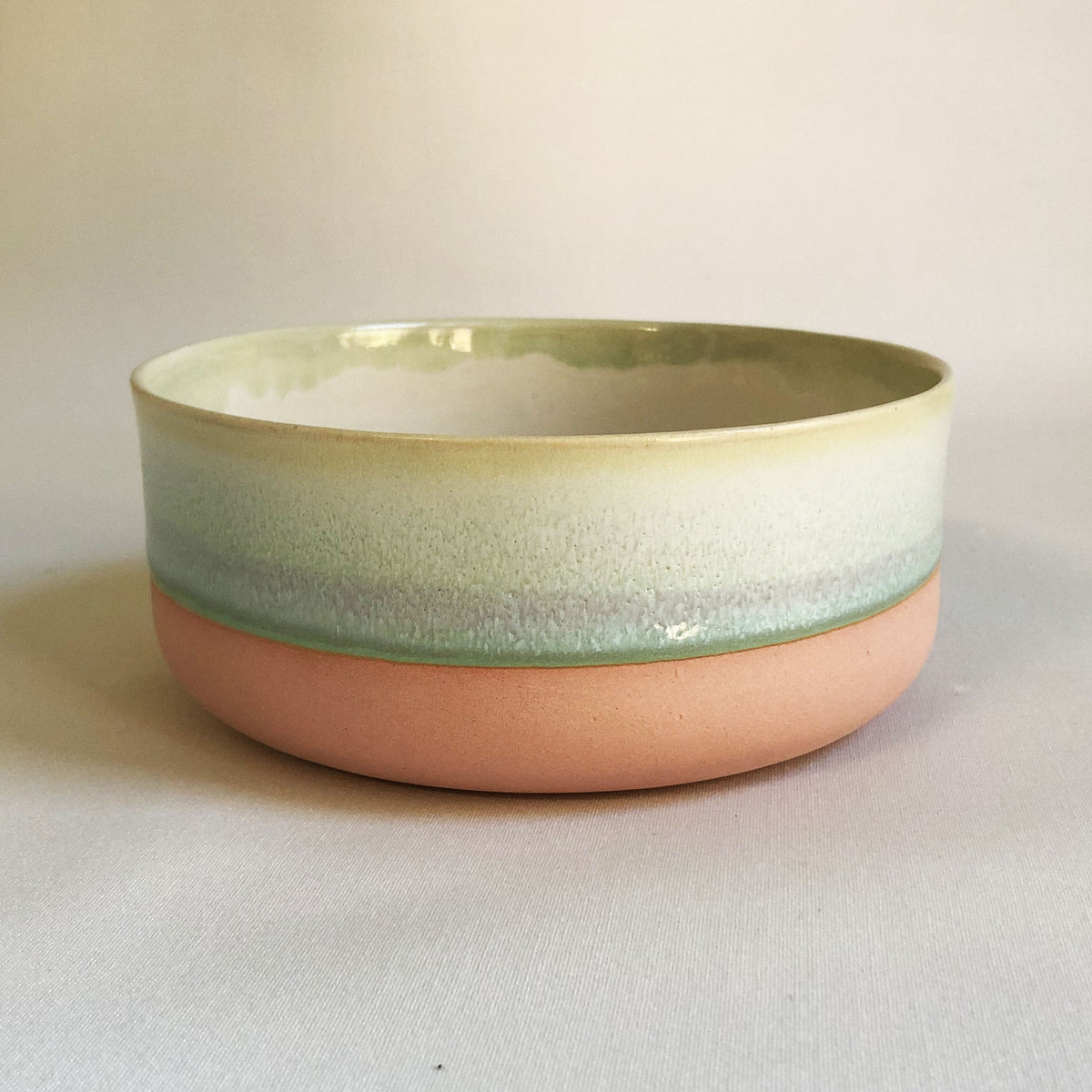 Large bowl with light pink bottom and green glaze