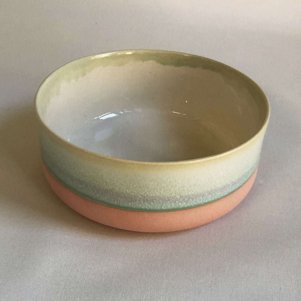 Large bowl with light pink bottom and green glaze