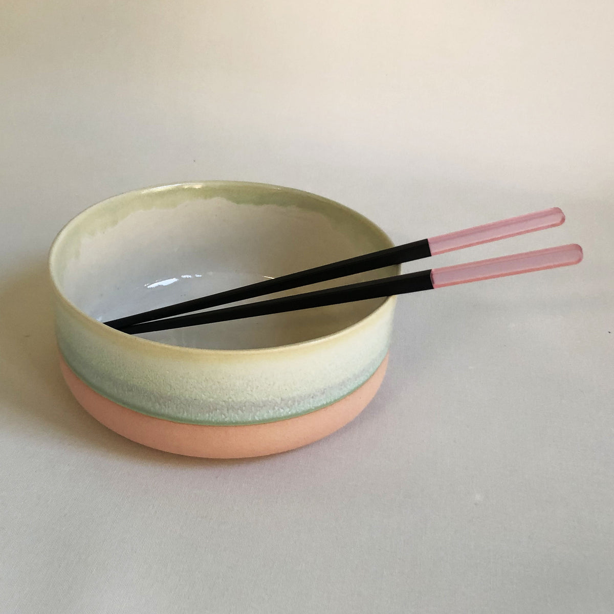 Large bowl with light pink bottom and green glaze