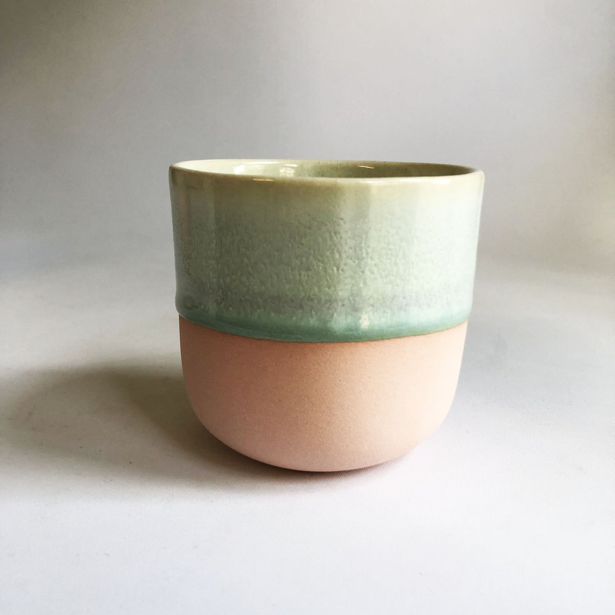 Large cup without handle with a matte light pink base and green glaze