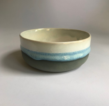 Small bowl with a matte dark grey base and ice-blue glaze