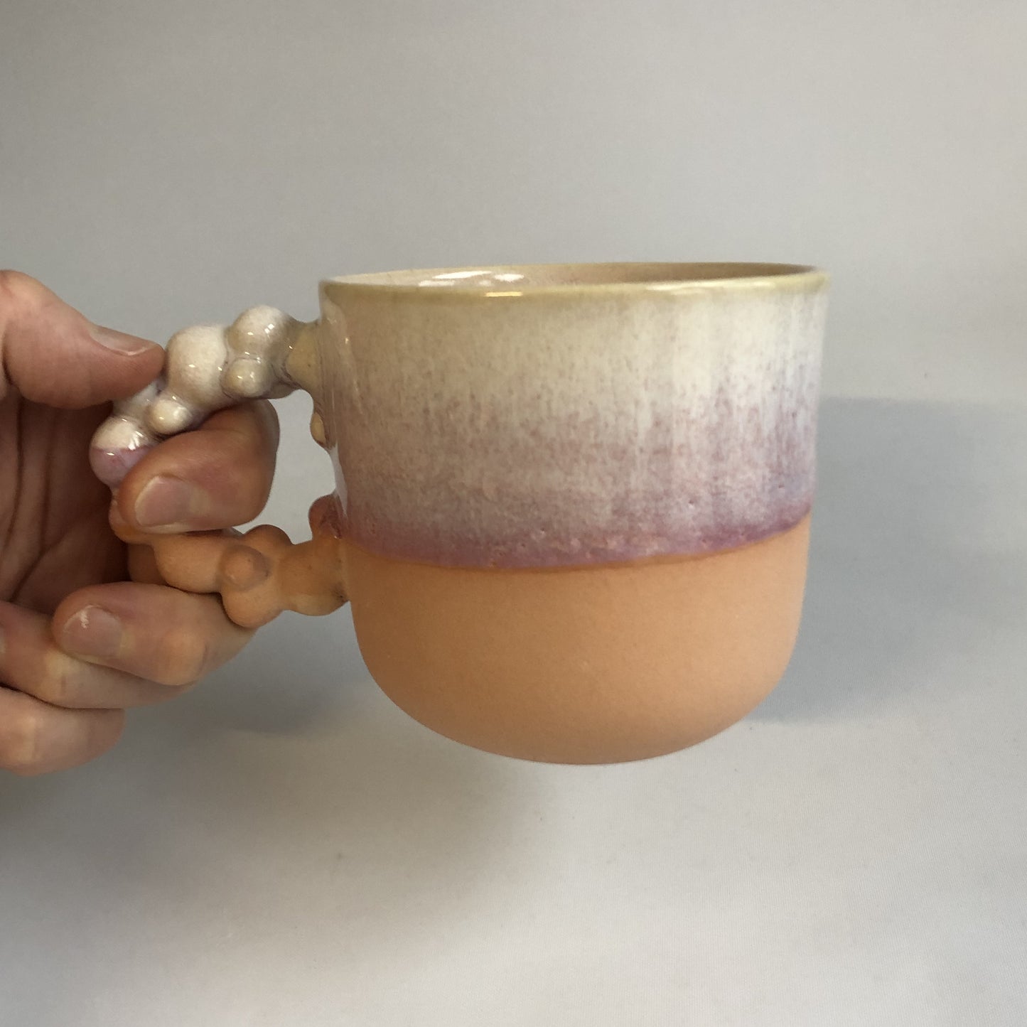 Stor kop med mat ferskenfarvet bund og lyserød glasur