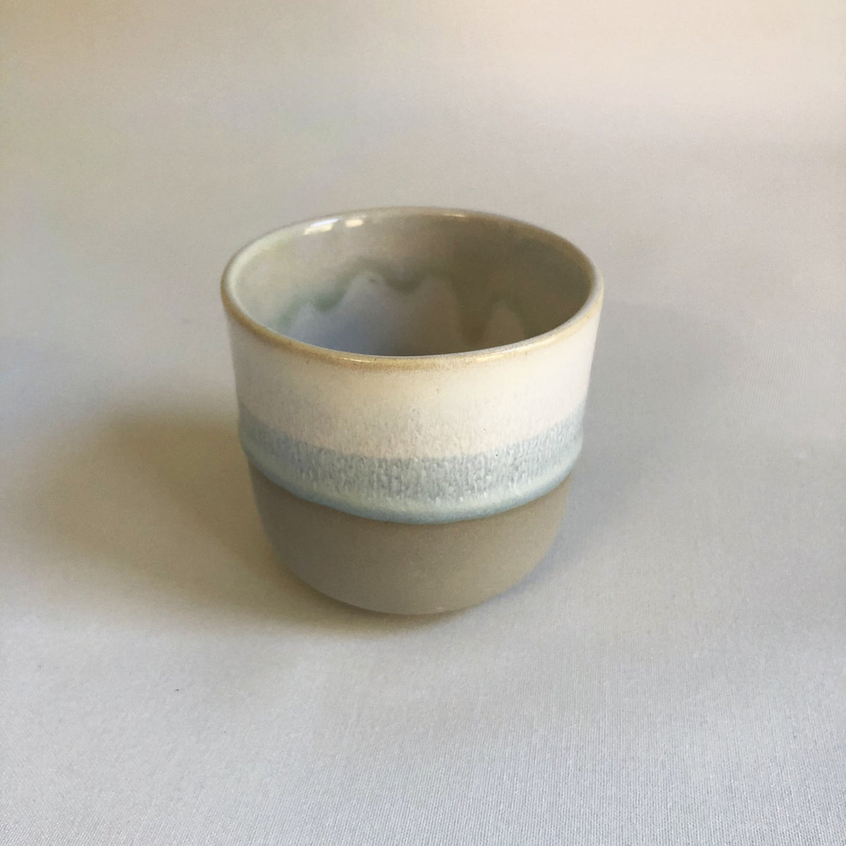 Large cup without a handle with a matte grey bottom and ice-blue glaze