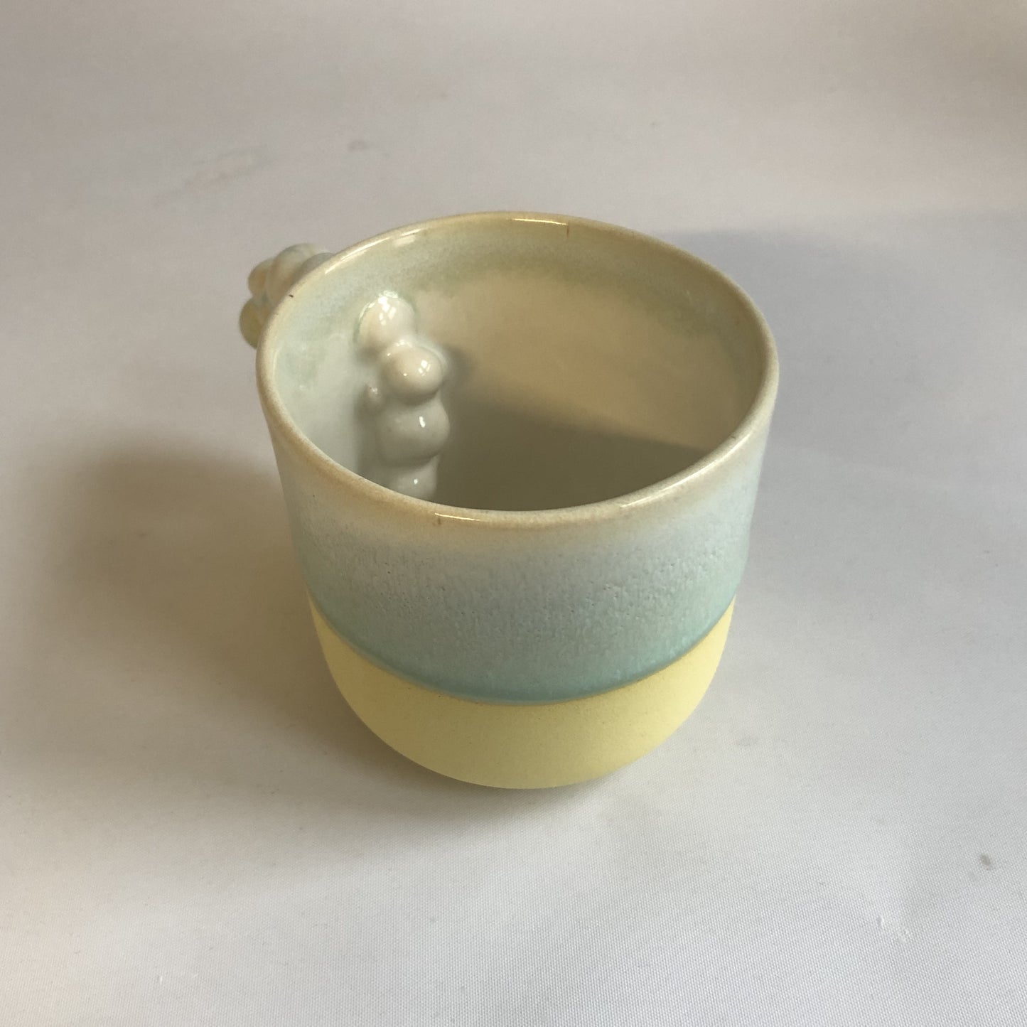 Stor kop med mat gul bund og grøn glasur