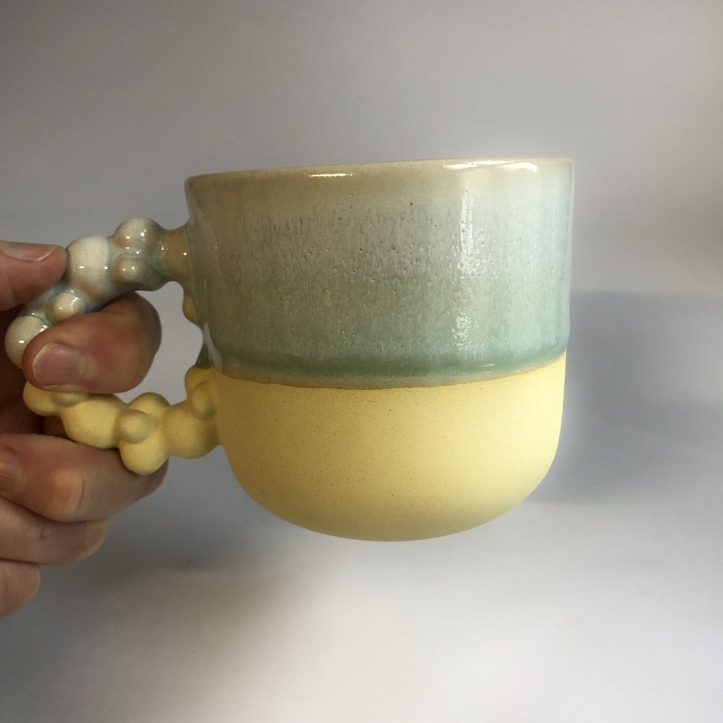 Stor kop med mat gul bund og grøn glasur